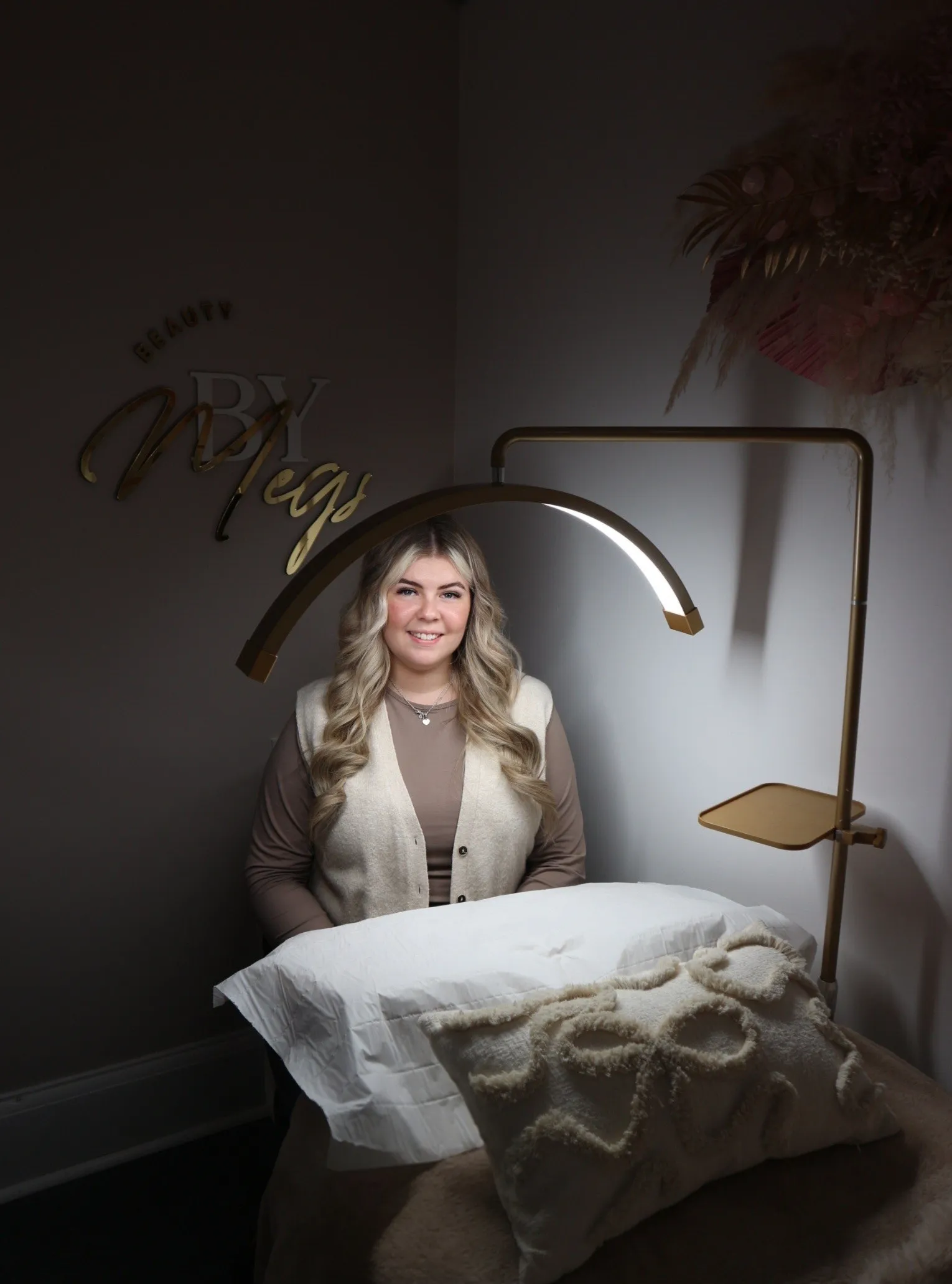Megan in her Hadleigh studio, beneath the gold lamp and her Beauty By Megs signage
